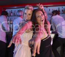 Two Young Women Having Fun In Busy Bar