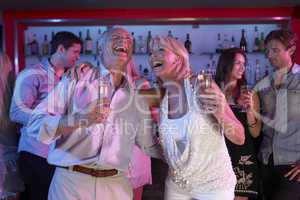 Senior Couple Having Fun In Busy Bar