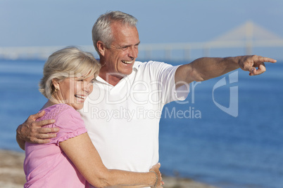 Happy Senior Couple Walking Pointing on Beach