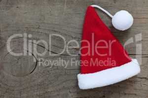 Weihnachtsmannmütze auf Holzuntergrund / santa hat on wooden bac