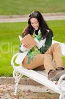 Autumn park bench  young woman read book