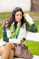 Autumn park bench  young woman hold phone