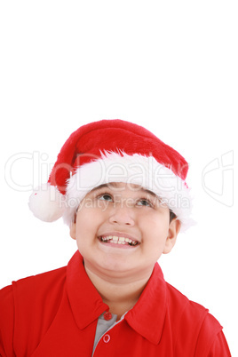 Cute little boy in Santa hat, looking up to copy space