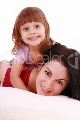 A portrait of a mother and her baby girl lying on the bed and sm