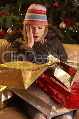 Müde junge Frau mit vielen Geschenken