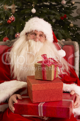 Weihnachtsmann sitzt vor dem Christbaum