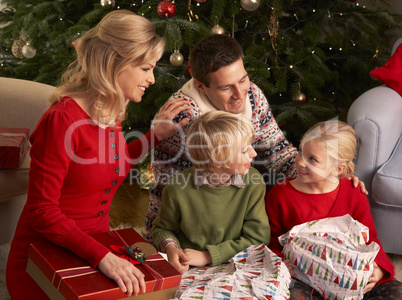 Glückliche Familie vor dem Christbaum