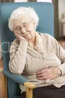 Senior Woman Resting In Chair At Home