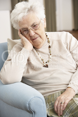 Senior Woman Looking Sad In Chair At Home