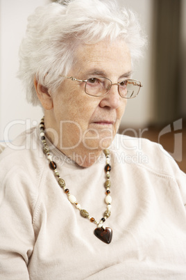 Senior Woman Looking Sad In Chair At Home
