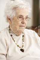 Senior Woman Looking Sad In Chair At Home
