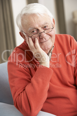 Senior Man Relaxing In Chair At Home