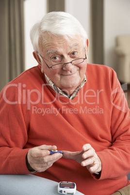 Senior Man Checking Blood Sugar Level At Home