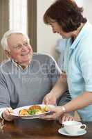 Senior Man Being Served Meal By Carer