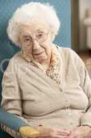 Senior Woman Looking Sad In Chair At Home