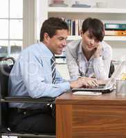 Couple Working From Home Using Laptop