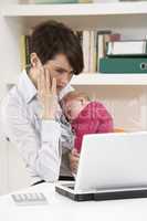 Stressed Woman With Newborn Baby Working From Home Using Laptop