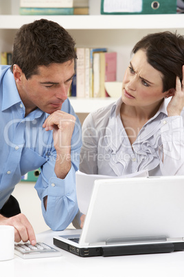 Worried Couple Working From Home Using Laptop