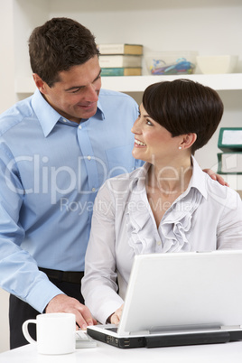 Couple Working From Home Using Laptop