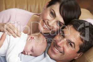 Portrait Of Proud Parents With Newborn Baby At Home