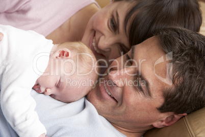 Portrait Of Proud Parents With Newborn Baby At Home