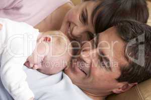 Portrait Of Proud Parents With Newborn Baby At Home