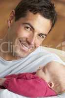 Portrait Of Father With Newborn Baby At Home