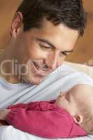 Portrait Of Father With Newborn Baby At Home