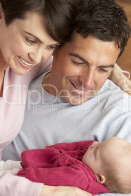 Portrait Of Proud Parents With Newborn Baby At Home