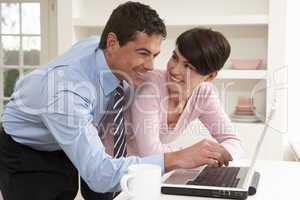 Couple Working From Home Using Laptop