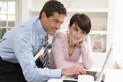 Couple Working From Home Using Laptop