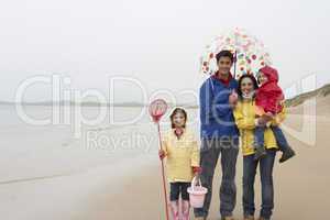 Happy family on beach with umbrella