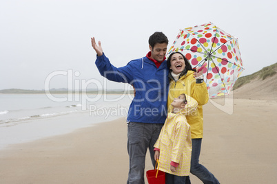 Happy family on beach with umbrella