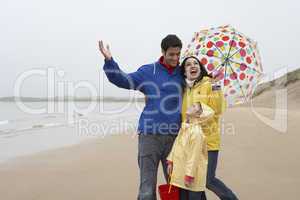 Happy family on beach with umbrella