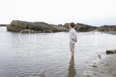 Boy daydreaming on beach