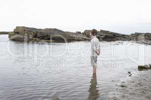 Boy daydreaming on beach