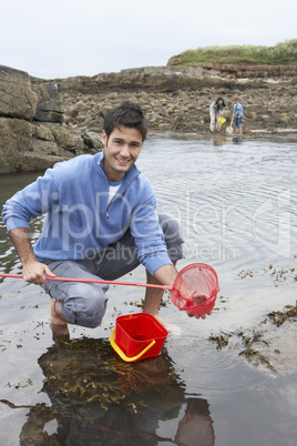 Young family at beach collecting shells