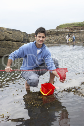 Young family at beach collecting shells