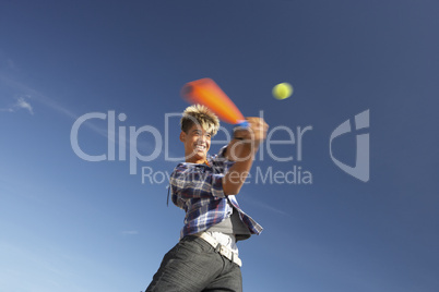 Boy playing cricket on beach