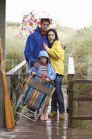 Family on beach with umbrella