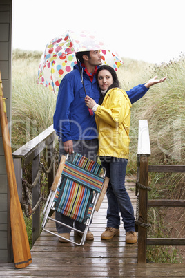 Young couple on beach with umbrella