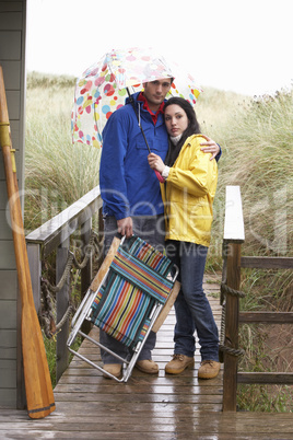 Young couple on beach with umbrella