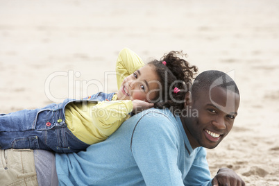 Father and daughter laying on beach