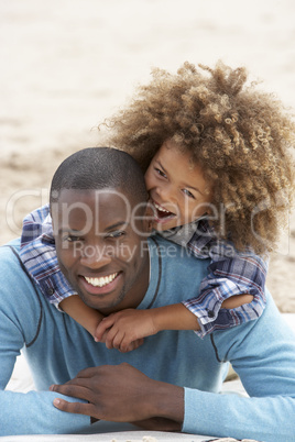 Father and son playing piggyback on beach