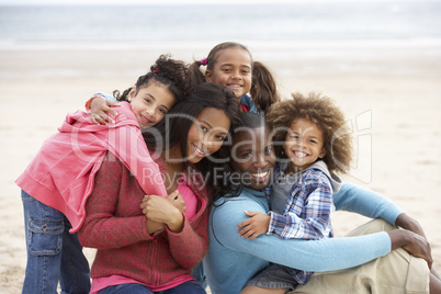 Young mixed race family embracing on beach