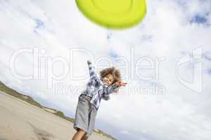 Boy playing frisbee on beach