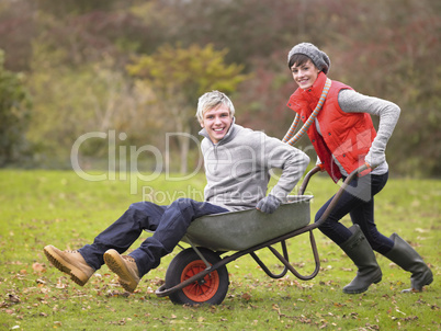 Young couple playing in wheelbarrow