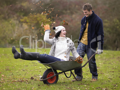 Young couple playing in wheelbarrow