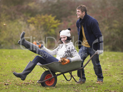 Young couple playing in wheelbarrow