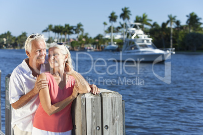Happy Senior Couple By River or Sea with Boat